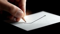 Hand holding pencil drawing single continuous line on white paper with dramatic lighting creating artistic shadow effects for creative projects.