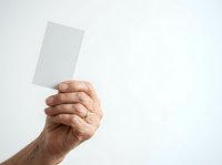 Mature male hand holding blank white card against neutral background, isolated on white for design mockups, presentations, advertising campaigns, and business communications.