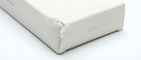 White cardboard box with torn corner showing wear and damage, isolated on white background for product packaging and shipping concepts.