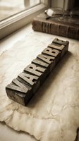 Vintage wooden letterpress type blocks spelling ARTICLE on aged paper near window with antique book, nostalgic publishing and printing concept.