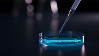 Laboratory pipette dispensing blue liquid into petri dish for scientific research and medical testing experiments in modern lab setting.