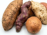 Fresh organic sweet potatoes and yams variety isolated on white background for healthy cooking and nutrition concepts.