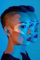 Asian woman with short undercut hairstyle in creative double exposure portrait under dramatic blue lighting, wearing bold red lipstick and artistic makeup for fashion editorial.