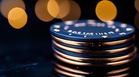 Stacked metallic camera lens filters with golden bokeh lights in background creating artistic photography composition on dark surface.