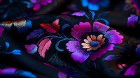 Vibrant floral embroidery pattern on black fabric featuring pink, purple, and blue blooms with metallic thread details, creating an elegant oriental textile design.