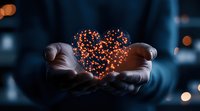 Glowing orange heart shape made of light particles floating between cupped hands against dark background, creating magical atmosphere for romantic concepts.