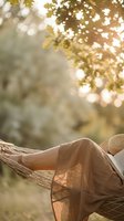 Person relaxing in hammock under golden autumn foliage with dappled sunlight, ideal for wellness, lifestyle and seasonal content.
