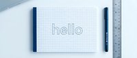 Grid notebook with hello text, pen and ruler on white desk, minimalist stationery flat lay for business, education and design concepts.