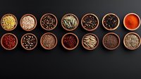 Aromatic spices and seasonings in wooden bowls arranged in neat rows on dark background, featuring colorful peppercorns, seeds, and ground spices for cooking and seasoning.