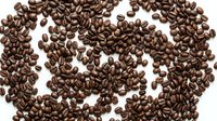 Roasted coffee beans scattered on white background, isolated for cafe menu design, beverage branding and culinary projects.