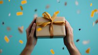 Hands holding wrapped present with gold ribbon against turquoise background with falling confetti, celebrating special occasion or holiday season.