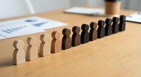 Wooden human figures arranged in gradient from light to dark representing diversity, inclusion and equality concepts for business presentations.
