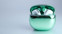 Modern green wireless earbuds in charging case on clean background for technology and audio device concepts.