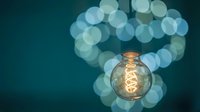 Vintage Edison bulb glowing warmly against soft bokeh lights background creating cozy atmospheric lighting for creative projects and design concepts.
