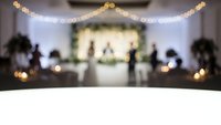Blurred wedding ceremony venue with warm string lights and elegant decor creating romantic atmosphere for celebration and special events.