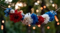 Patriotic floral garland with red, white and blue chrysanthemums against blurred bokeh lights background creates festive holiday atmosphere.