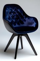 Modern armchair with quilted navy blue velvet upholstery and black wooden legs on light background, contemporary furniture design for luxury interior.