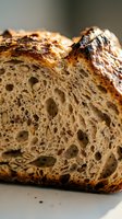 Freshly baked artisan sourdough bread slice with crispy golden crust and airy crumb structure, ideal for bakery, food, and culinary content.