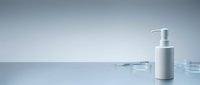 Silver pump bottle with dropper on reflective surface for skincare, cosmetics, serum, or medical product packaging design and branding.