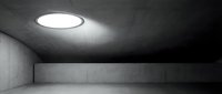 Modern minimalist concrete interior with circular ceiling light fixture creating ambient illumination in empty architectural space for design and commercial projects.