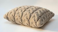 Cozy beige cable knit throw pillow with textured wool pattern on white background, isolated for home decor and interior design projects.