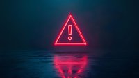 Glowing red neon warning triangle with exclamation mark floating above reflective dark surface in foggy atmosphere.