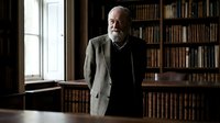Elderly Caucasian male scholar standing in a classic library with bookshelves, natural window light, conveying wisdom, knowledge, and academic authority.