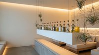 Modern minimalist home bar with floating shelves, ambient lighting, and hanging plants creating sophisticated entertaining space for luxury interior design.
