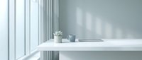 Minimalist white desk setup with small potted plant and cup near window with vertical blinds casting natural light shadows on pale blue wall.