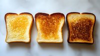 Three slices of bread showing different toasting levels from light golden to dark brown, perfect for breakfast and cooking concepts.