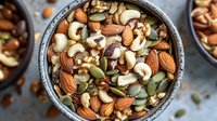 Mixed nuts and seeds in rustic bowl with almonds, cashews, walnuts, pumpkin seeds. Healthy snacking, protein-rich food, nutritious ingredients for cooking and baking.
