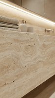Luxury travertine marble bathroom vanity with LED strip lighting, folded towels and toiletries creating elegant spa-like interior design atmosphere.