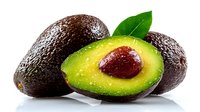 Fresh ripe avocados with one cut in half showing creamy green flesh and brown seed, accompanied by green leaf on white background.