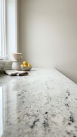 Minimalist kitchen counter with white granite surface, ceramic teapot and fresh lemons creating clean modern interior design for home decor and cooking spaces.