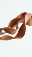 Flowing brown satin ribbon waves creating elegant curves and loops against white background for luxury packaging and gift wrapping designs.