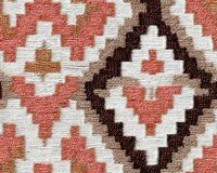 Geometric diamond pattern in coral pink, brown and white on woven textile surface creates traditional southwestern style design. Seamless repeat for fabric and interior decor.