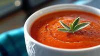 Fresh tomato soup in white bowl garnished with herbs, homemade comfort food for restaurant menu or cooking blog content.