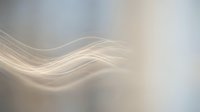 Abstract flowing waves in soft beige and gray tones creating elegant motion blur effect for modern design backgrounds and digital art projects.