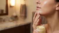 Young woman applying moisturizing cream to neck in modern bathroom. Skincare routine, anti-aging treatment, beauty wellness concept for cosmetic products.