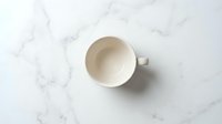 Empty ceramic mug on marble surface, overhead view. Isolated on white background, ready for product mockup, branding, and design projects.