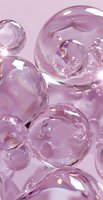 Transparent soap bubbles with iridescent reflections floating on pink background. Macro photography of delicate spheres with rainbow light effects and glossy surface.