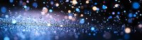 Abstract blue and purple bokeh background with glowing particles and light spots creating magical atmosphere for festive designs.
