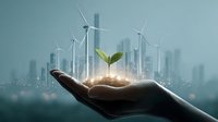 Hand holding soil with green seedling against urban skyline with wind turbines, representing sustainable development and renewable energy solutions.