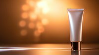 White cosmetic tube on reflective surface against warm bokeh background with metallic cap and soft lighting effects for beauty product advertising.