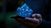 Glowing blue holographic house projection emerging from smartphone screen held in male hand, depicting futuristic real estate technology concept in dark setting.