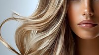 Close up view of flowing blonde highlighted hair and full lips with natural makeup on light background, beauty and hair care concept for salon advertising.