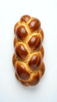 Fresh braided challah bread with golden brown crust and sesame seeds isolated on white background for bakery and food design projects.