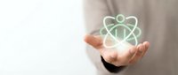 Scientist or researcher holding glowing atom symbol in palm, representing science, innovation, and atomic energy research for educational and technology concepts.
