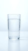 Clear glass filled with sparkling water showing carbonation bubbles on clean white background for health and hydration concepts.
