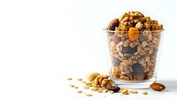 Homemade granola with nuts, dried fruits and seeds in glass jar on white background. Healthy breakfast cereal mix for morning meal preparation.